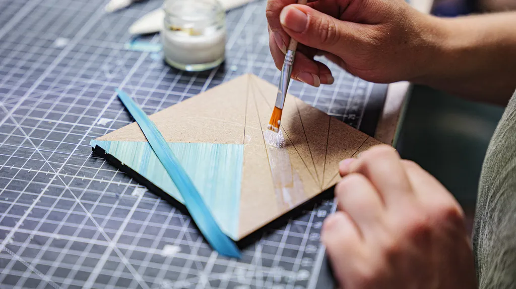 Personne étalant de la colle avec un pinceau.